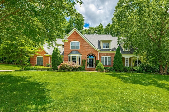 9542 Legacy Oaks Dr, Ooltewah, TN 37363 - traditional-style house featuring brick siding, a front yard, and roof with shingles