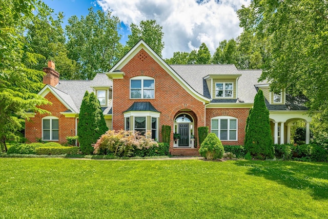 9542 Legacy Oaks Dr, Ooltewah, TN 37363 - view of front of property with a front lawn, brick siding, a chimney, and roof with shingles