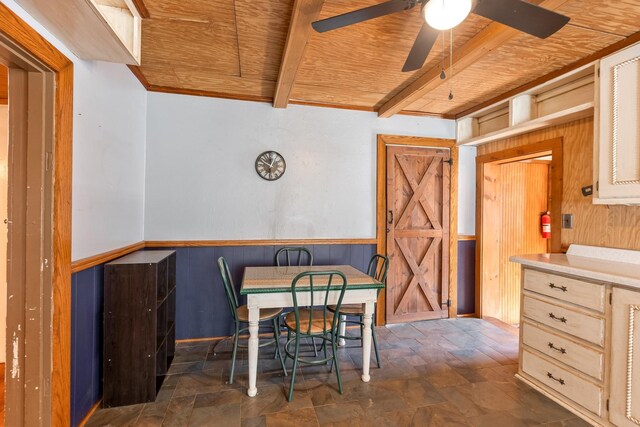 5312 Wiley Hollow Rd, Culleoka, TN 38451 - dining area with wood ceiling with exposed beams, a ceiling fan, stone finish flooring, wooden walls, and wainscoting