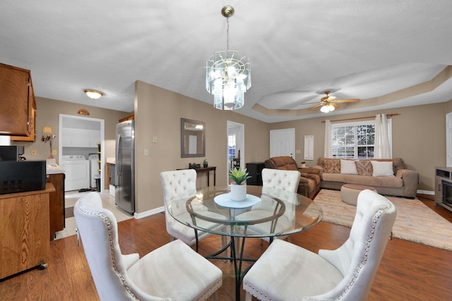 2879 Chinquapin Ln, Clarksville, TN 37043 - dining space featuring wood finished floors, a ceiling fan, a chandelier, baseboards, and washer and clothes dryer