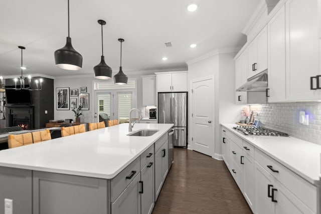 2122 Notchleaf Rd, Antioch, TN 37013 - kitchen featuring appliances with stainless steel finishes, under cabinet range hood, a sink, crown molding, and gray cabinetry