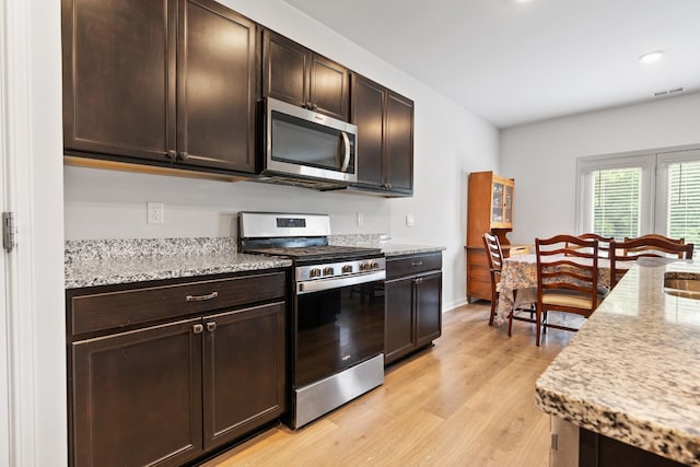 5073 Hunters Village Dr, Lebanon, TN 37087 - kitchen with stainless steel appliances, light wood-type flooring, dark brown cabinetry, light stone counters, and recessed lighting