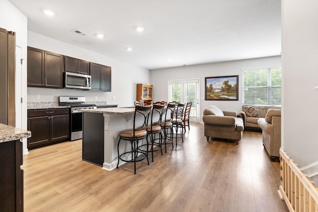 5073 Hunters Village Dr, Lebanon, TN 37087 - kitchen featuring stainless steel appliances, light wood-style flooring, a kitchen bar, dark brown cabinetry, and recessed lighting