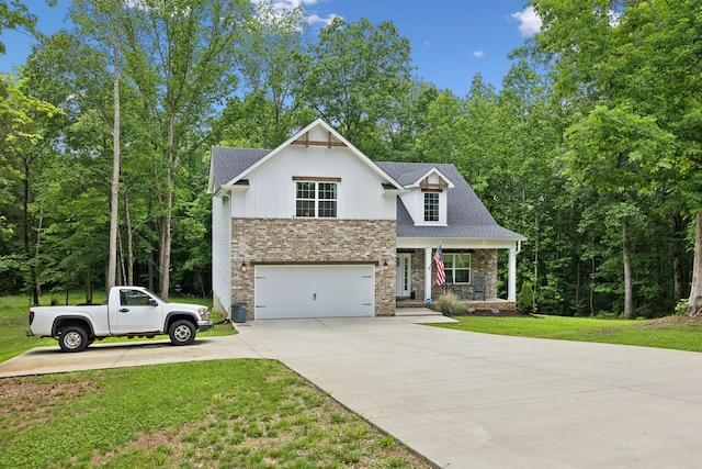 3650 Riggins Rd, Cumberland Furnace, TN 37051 - view of front facade featuring concrete driveway, a porch, an attached garage, a front yard, and stone siding