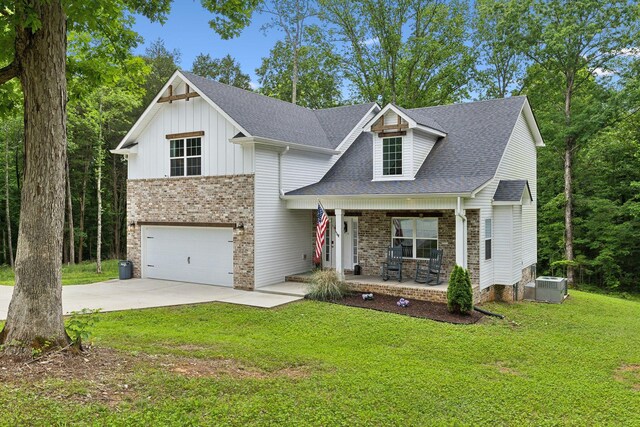 3650 Riggins Rd, Cumberland Furnace, TN 37051 - view of front of house featuring a porch, central air condition unit, a garage, concrete driveway, and a front yard