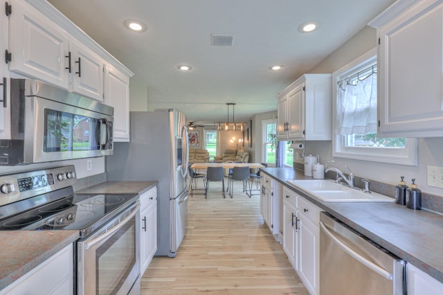 1713 Hollow Oak Dr, Lebanon, TN 37087 - kitchen featuring appliances with stainless steel finishes, a sink, white cabinetry, light wood finished floors, and recessed lighting