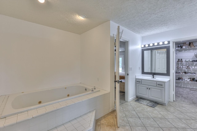 1713 Hollow Oak Dr, Lebanon, TN 37087 - bathroom featuring a jetted tub, vanity, tile patterned flooring, and a textured ceiling