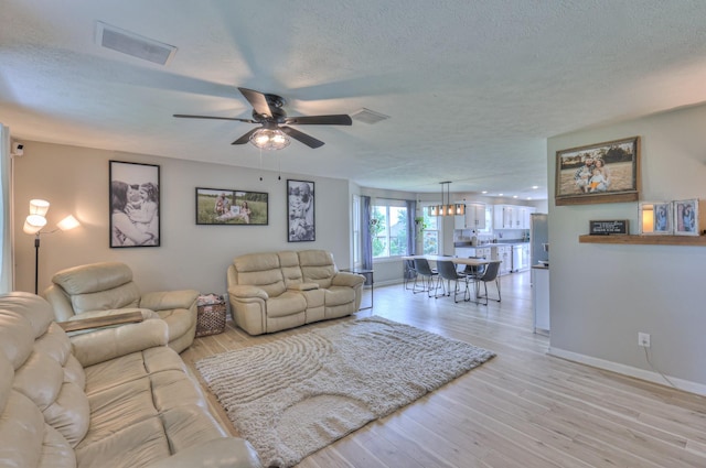 1713 Hollow Oak Dr, Lebanon, TN 37087 - living room featuring ceiling fan, a textured ceiling, baseboards, and light wood-type flooring