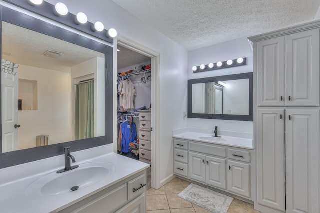 1713 Hollow Oak Dr, Lebanon, TN 37087 - bathroom featuring two vanities, tile patterned flooring, and a textured ceiling