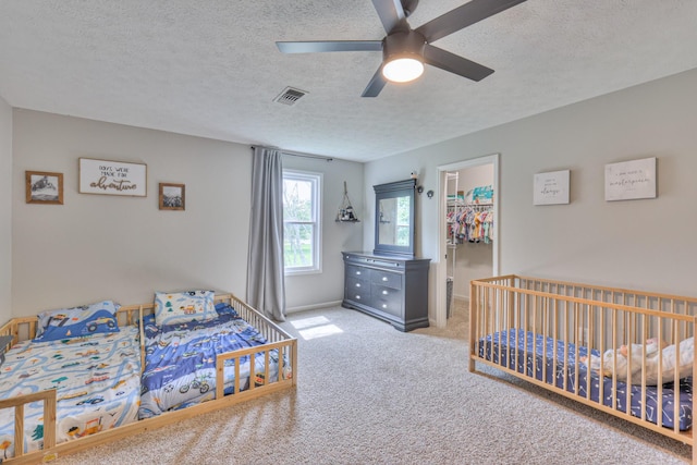 1713 Hollow Oak Dr, Lebanon, TN 37087 - bedroom with carpet, a textured ceiling, a walk in closet, ceiling fan, and a closet