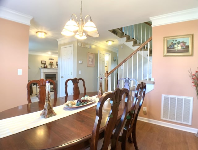 1635 Barrywood Cir E, Clarksville, TN 37042 - dining space featuring ornamental molding, stairs, a chandelier, wood finished floors, and a fireplace