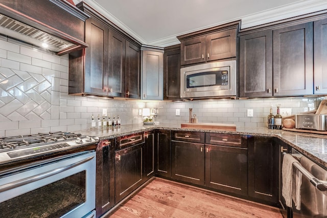 134 Fitzgerald St, Franklin, TN 37064 - kitchen featuring stainless steel appliances, premium range hood, stone counters, light wood-style flooring, and decorative backsplash