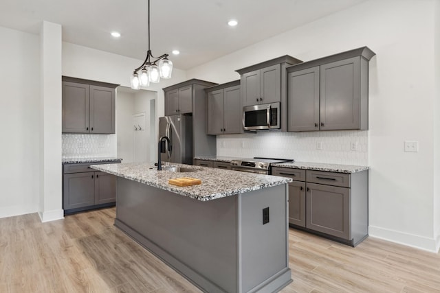 338 Dugout Rd, Summertown, TN 38483 - kitchen featuring stainless steel appliances, decorative backsplash, an island with sink, light stone countertops, and recessed lighting
