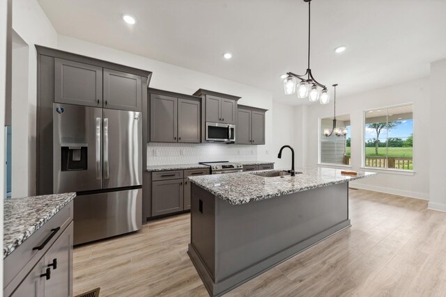 338 Dugout Rd, Summertown, TN 38483 - kitchen featuring appliances with stainless steel finishes, a sink, light stone counters, decorative backsplash, and a chandelier