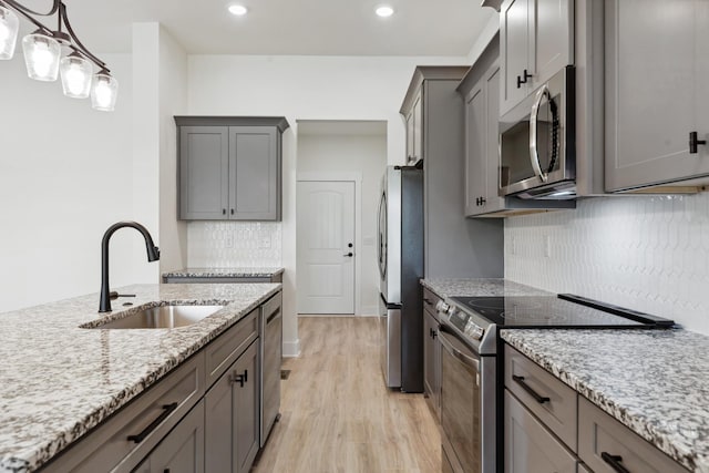 338 Dugout Rd, Summertown, TN 38483 - kitchen featuring appliances with stainless steel finishes, a sink, gray cabinets, light wood-style floors, and decorative backsplash
