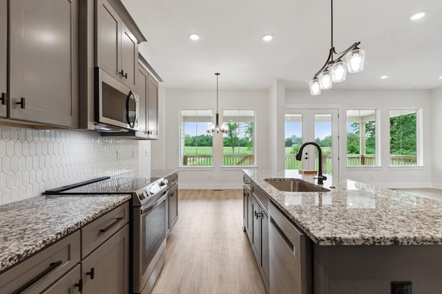 338 Dugout Rd, Summertown, TN 38483 - kitchen featuring a sink, stainless steel appliances, light wood-type flooring, baseboards, and backsplash