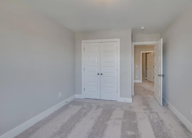 135 Grandstand Blvd, Gallatin, TN 37066 - unfurnished bedroom featuring a closet, light carpet, and baseboards