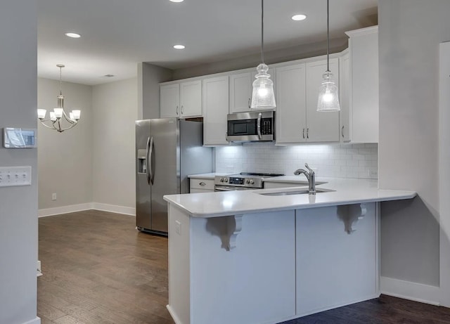 135 Grandstand Blvd, Gallatin, TN 37066 - kitchen with appliances with stainless steel finishes, a sink, a breakfast bar, dark wood-style floors, and recessed lighting
