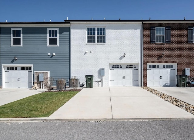 135 Grandstand Blvd, Gallatin, TN 37066 - rear view of house featuring a garage, concrete driveway, brick siding, and cooling unit