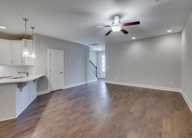 135 Grandstand Blvd, Gallatin, TN 37066 - unfurnished living room with a ceiling fan, a sink, baseboards, dark wood-style flooring, and stairway