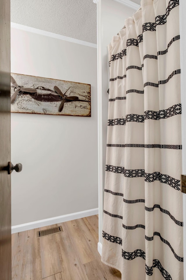 130 Shane Lee Cir, Dover, TN 37058 - full bathroom with wood finished floors, ornamental molding, baseboards, curtained shower, and a textured ceiling