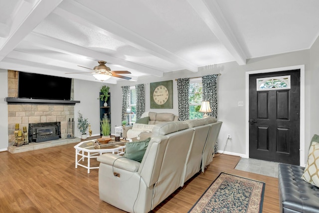 130 Shane Lee Cir, Dover, TN 37058 - living area featuring baseboards, wood finished floors, ceiling fan, a stone fireplace, and beam ceiling