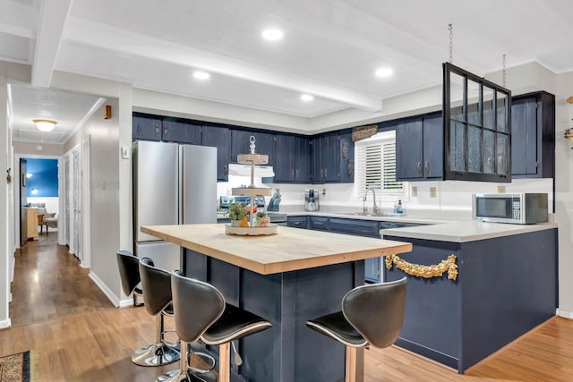 130 Shane Lee Cir, Dover, TN 37058 - kitchen featuring butcher block counters, stainless steel appliances, blue cabinetry, a kitchen breakfast bar, and beamed ceiling
