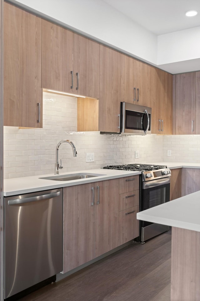 1212 Demonbreun St N Unit A5, Nashville, TN 37203 - kitchen featuring stainless steel appliances, a sink, light countertops, modern cabinets, and dark wood-style flooring