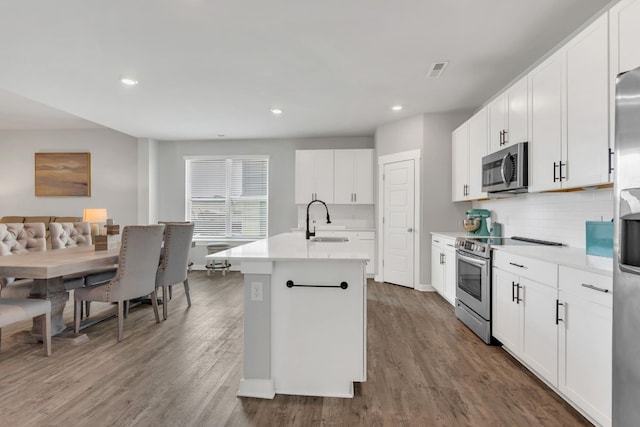 129 Southwind Run, Spring Hill, TN 37174 - kitchen featuring stainless steel appliances, a kitchen island with sink, tasteful backsplash, wood finished floors, and recessed lighting