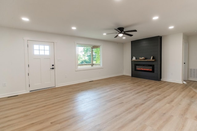 1320 Napier Lake Rd, Hohenwald, TN 38462 - unfurnished living room featuring a large fireplace, recessed lighting, ceiling fan, light wood finished floors, and baseboards