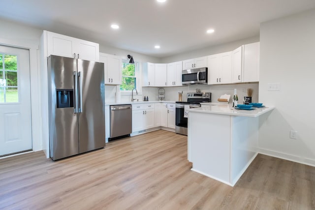 1320 Napier Lake Rd, Hohenwald, TN 38462 - kitchen with stainless steel appliances, a peninsula, light wood-style floors, light countertops, and recessed lighting