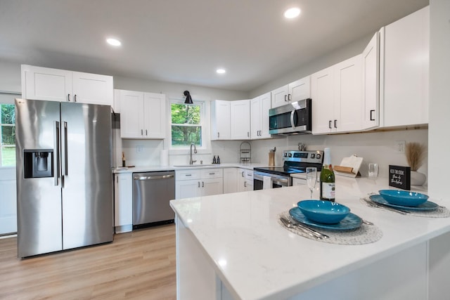 1320 Napier Lake Rd, Hohenwald, TN 38462 - kitchen with stainless steel appliances, a sink, a peninsula, white cabinets, and recessed lighting