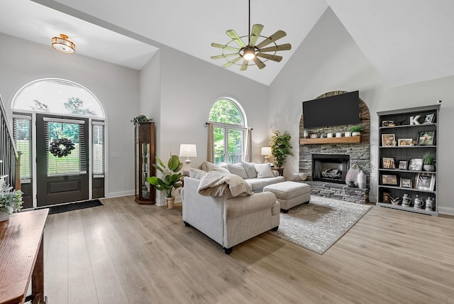 1415 Southside Rd, Southside, TN 37171 - living area with high vaulted ceiling, a ceiling fan, light wood-type flooring, and a stone fireplace