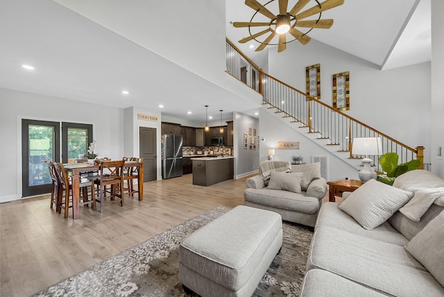 1415 Southside Rd, Southside, TN 37171 - living room featuring stairs, recessed lighting, light wood-style flooring, a ceiling fan, and a towering ceiling