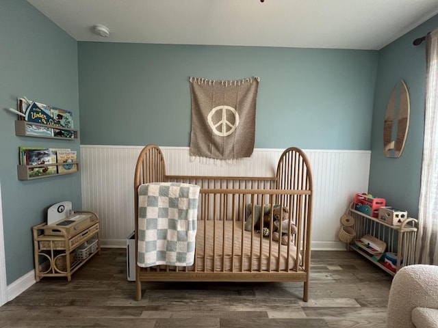 219 Dugger Dr, Clarksville, TN 37042 - bedroom featuring wainscoting, a crib, and wood finished floors