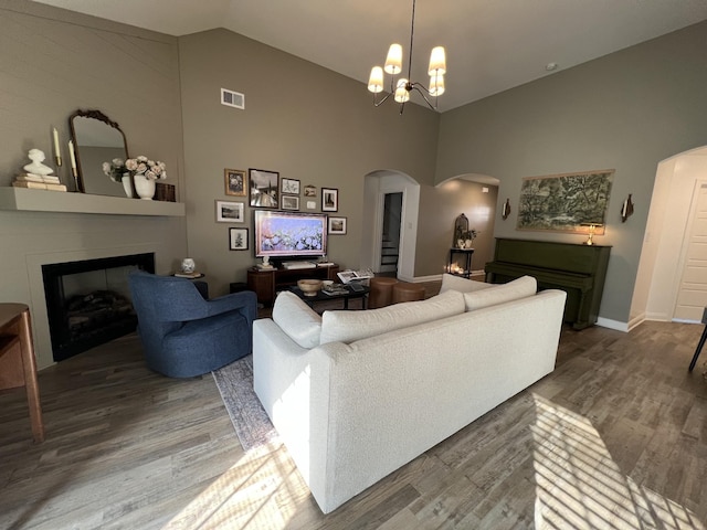 219 Dugger Dr, Clarksville, TN 37042 - living room with arched walkways, a large fireplace, wood finished floors, high vaulted ceiling, and baseboards