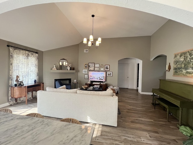 219 Dugger Dr, Clarksville, TN 37042 - living room with arched walkways, wood finished floors, a chandelier, baseboards, and high vaulted ceiling