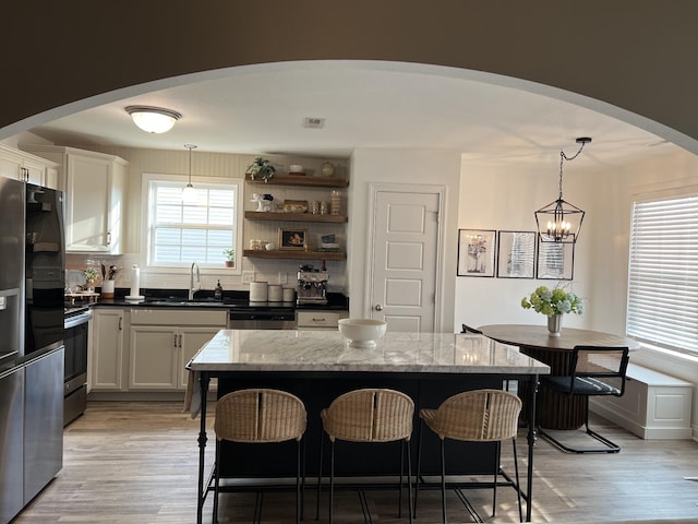 219 Dugger Dr, Clarksville, TN 37042 - kitchen with arched walkways, a sink, a breakfast bar area, and healthy amount of natural light