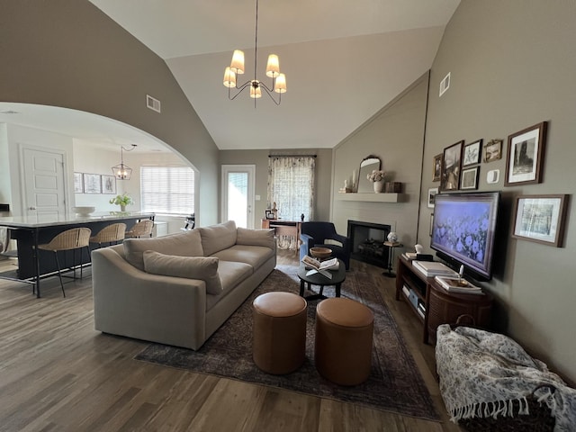 219 Dugger Dr, Clarksville, TN 37042 - living room featuring a chandelier, wood finished floors, arched walkways, plenty of natural light, and high vaulted ceiling