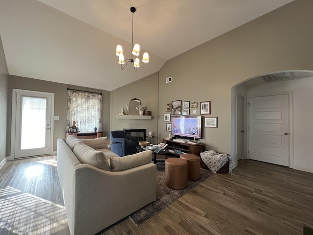 219 Dugger Dr, Clarksville, TN 37042 - living area featuring arched walkways, wood finished floors, high vaulted ceiling, a glass covered fireplace, and a chandelier