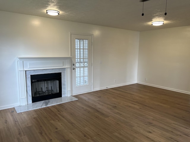 3048 Chateau Valley Dr, Nashville, TN 37207 - unfurnished living room featuring dark wood-style flooring, baseboards, a premium fireplace, and a textured ceiling