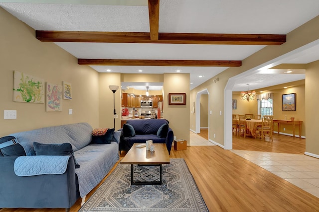 891 Deepwoods Rd, Sewanee, TN 37375 - living area with a chandelier, arched walkways, light tile patterned floors, beamed ceiling, and baseboards