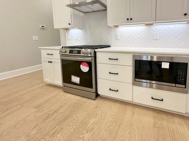 7131 Frances St, Fairview, TN 37062 - kitchen featuring appliances with stainless steel finishes, under cabinet range hood, light countertops, tasteful backsplash, and white cabinets