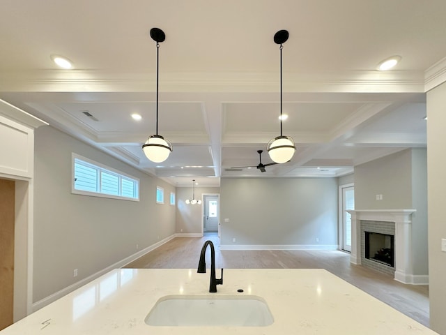 7131 Frances St, Fairview, TN 37062 - kitchen featuring a fireplace, coffered ceiling, pendant lighting, light wood-style floors, and light stone counters