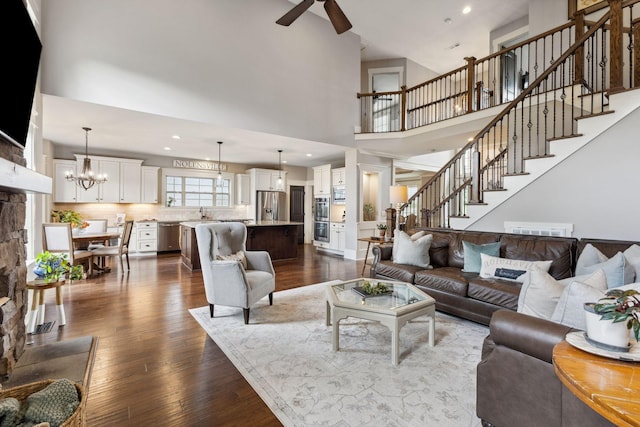 9201 Dutch Belted Ct, Nolensville, TN 37135 - living room with a ceiling fan, dark wood-style floors, stairway, a high ceiling, and a chandelier