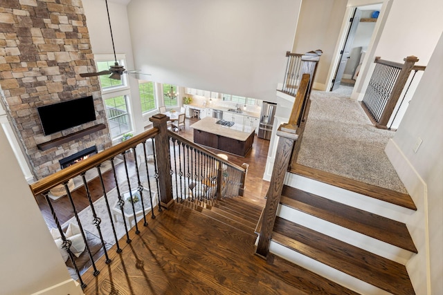 9201 Dutch Belted Ct, Nolensville, TN 37135 - stairway with wood finished floors, a ceiling fan, a fireplace, a high ceiling, and baseboards