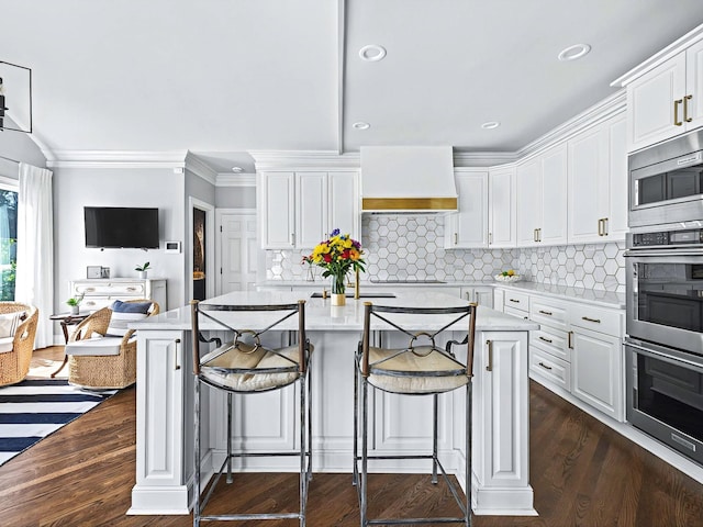 1004 Jones Pkwy, Brentwood, TN 37027 - kitchen featuring appliances with stainless steel finishes, white cabinetry, crown molding, custom exhaust hood, and a kitchen island