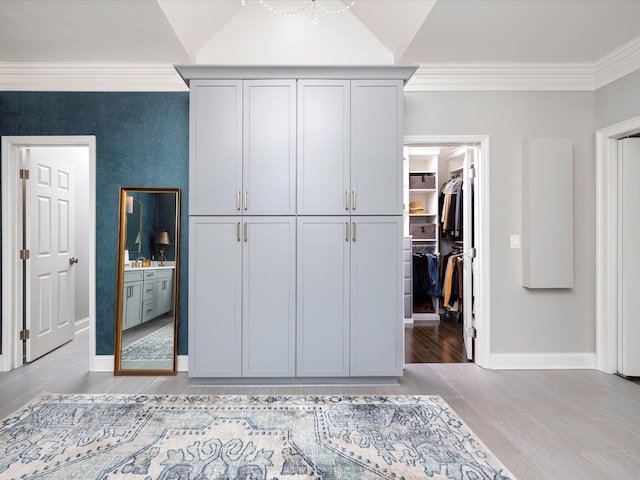 1004 Jones Pkwy, Brentwood, TN 37027 - unfurnished bedroom featuring a walk in closet, crown molding, baseboards, wood finished floors, and a closet