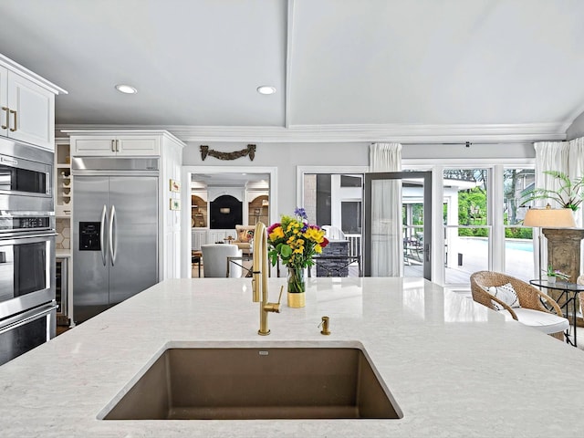 1004 Jones Pkwy, Brentwood, TN 37027 - kitchen featuring built in appliances, a sink, ornamental molding, recessed lighting, and light stone counters