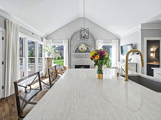 1004 Jones Pkwy, Brentwood, TN 37027 - dining space with vaulted ceiling, a fireplace, crown molding, and a chandelier